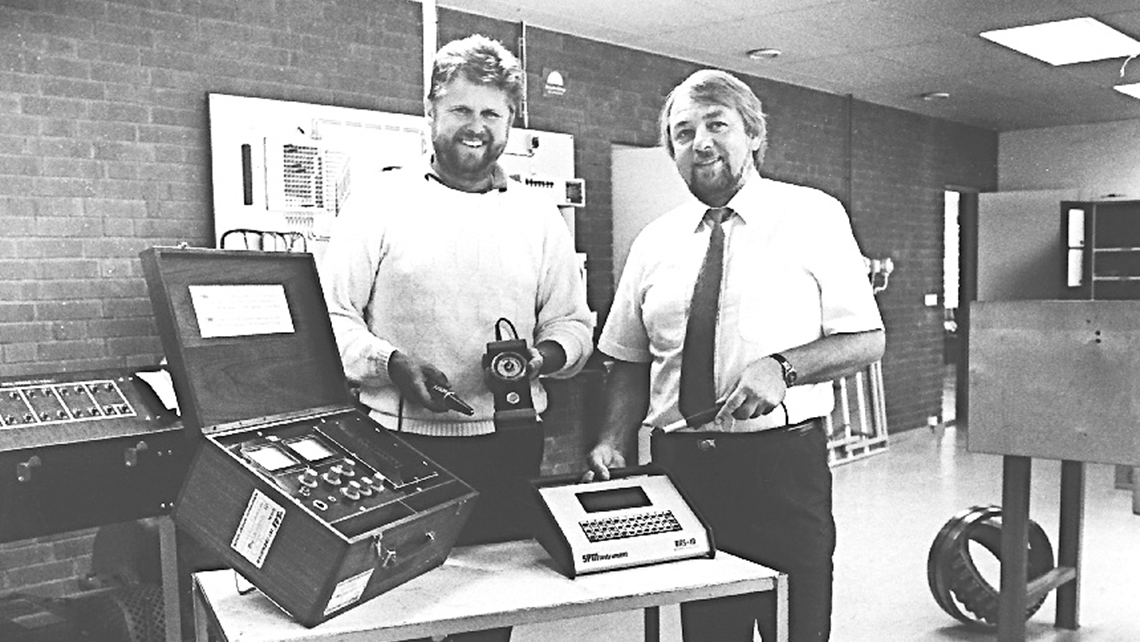 Two SPM representatives showing measuring instruments from SPM in the early days